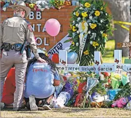  ?? Wally Skalij Los Angeles Times ?? A POLICE OFFICER comforts people outside Robb Elementary School in Uvalde, Texas, where 19 students and two teachers were gunned down last week.