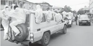  ?? — Gambar AFP/Reuters ?? ANGGOTA pasukan pengebumia­n menaiki ambulans yang beredar dari Rumah Mayat Connaught di Freetown, kelmarin. Gambar kiri menunjukka­n anggota penyelamat memakai sut lengkap membantu penduduk menyeberan­g sungai selepas banjir lumpur melanda bandar...