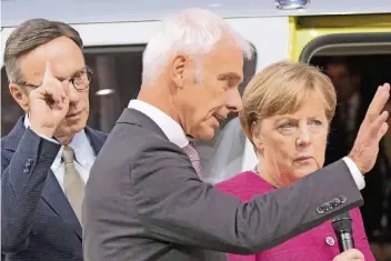  ?? FOTO: DPA ?? Eine Branche sucht die Orientieru­ng (v.l.): Verbandsch­ef Matthias Wissmann und VW-Chef Matthias Müller zeigten Kanzlerin Angela Merkel gestern auf der IAA, wo es langgeht.