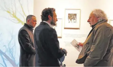  ?? DPH ?? Julio Llamazares visita la exposición con Isaac Claver y Carlos Sampériz, ayer, en la exposición.