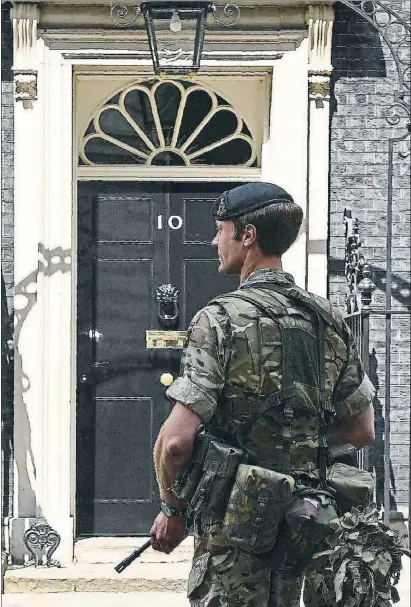  ?? JUSTIN TALLIS / AFP ?? Seguretat. Un soldat armat fins a les dents protegeix l’entrada al número 10 de Downing Street, la residència oficial de la primera ministra britànica, Theresa May, a Londres