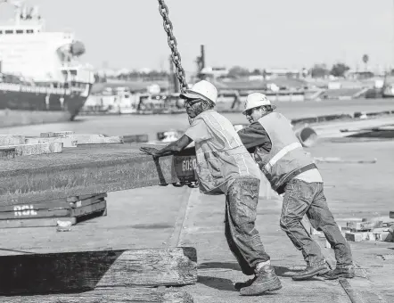  ?? Photos by Steve Gonzales / Staff photograph­er ?? Longshorem­en unload Mexican steel at the Port of Houston. Some fear a repeat of 2002, when President George W. Bush imposed tariffs.