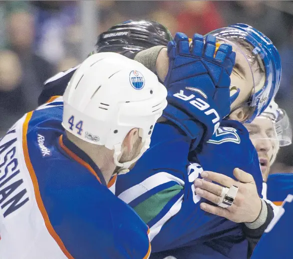  ?? GETTY IMAGES FILES ?? Zack Kassian, left, of the Oilers gets his glove in the face of Nikita Tryamkin of the Canucks on April 8 at Rogers Arena. In Russian interviews after deciding to leave Vancouver, Tryamkin has talked openly about his lack of ice time and other areas of...