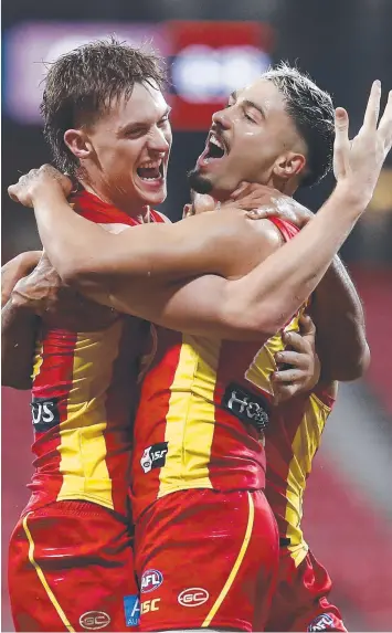  ?? Picture: GETTY ?? BRIGHT SIDE: Gold Coast’s Izak Rankine (right) celebrates kicking his first AFL goal.