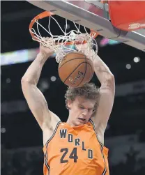  ?? [AP PHOTO] ?? Lauri Markkanen of the World Team and the Chicago Bulls dunks during the NBA All-Star Rising Stars basketball game against the U.S. team on Friday night at Staples Center.