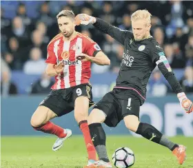  ??  ?? Leicester keeper Kasper Schmeichel clears as Fabio Borini moves in