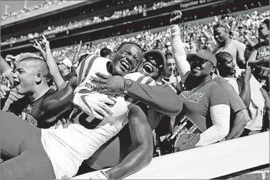  ?? [IAN MAULE/TULSA WORLD] ?? Matthew Eaton hugs his son, Iowa State receiver Matthew Eaton, after the Cyclones defeated Oklahoma. It was Iowa State’s first win over a ranked team since 2012.