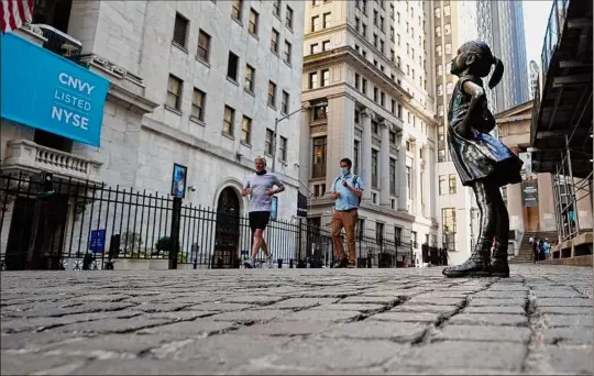  ?? Richard Drew / Associated Press ?? The “Fearless Girl” statue faces the New York Stock Exchange on June 16. Stocks are opening broadly higher on Wall Street Friday, keeping the S&P 500 on track for its biggest weekly gain since April.