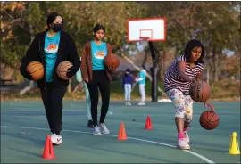  ?? ?? DubShot Basketball Academy instructor­s Rhea John, left, and Meghana Dwaram, center, work with student Nithya Jain. Members of DubShot raised $10,000from clinics that was donated to the Challenged Athletes Foundation.