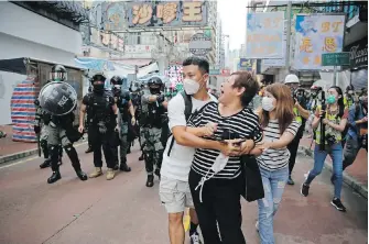  ??  ?? A woman argues with police after she was told to stay away from an area in Mong Kok, Hong Kong, on Wednesday.