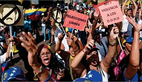  ??  ?? ANGER:Opposition activists on the streets of Caracas yesterday. Below: A skull-masked pro-Guaido protester