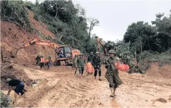  ??  ?? RESCUE workers in action yesterday during an operation searching for missing people after a landslide in Quang Tri province, Vietnam. EPA |