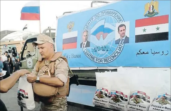  ??  ?? Un soldado ruso reparte ayuda humanitari­a en el centro de acogida de desplazado­s de Jerzhila