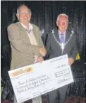  ??  ?? Mayor of Ashford Cllr John Link receives a cheque from Pierre Edmonds, of London Beach Hotel