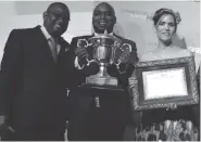  ??  ?? United Refineries Limited representa­tives holding a trophy and certificat­e won by Mr Busisa Moyo for being the Businessma­n of the Year