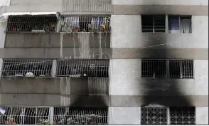  ?? AP/ARIANA CUBILLOS ?? Smoke damage streaks the outside of an apartment complex Sunday in Caracas, Venezuela, where an explosion and fire broke out Saturday as Venezuelan President Nicolas Maduro was delivering a speech to soldiers.