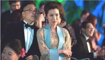  ??  ?? Tan Sri Michelle Yeoh in a scene from ‘Crazy Rich Asians’. — Warner Bros photo by Sanja Bucko