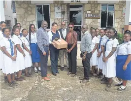  ?? PHOTO BY OKOYE HENRY ?? Gabrielle Lee (with package), senior account executive at Allied Insurance, hands over the donated projector to Stacey Reynolds (second from her left), principal at Mt. Alvernia High School in Montego Bay, St James. Students, teachers and other...