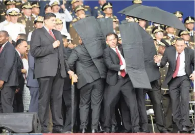  ?? PICTURE: XINHUA/AP/AFRICAN NEWS AGENCY (ANA) ?? LINE OF FIRE: Security personnel surround Venezuela’s President Nicolas Maduro during an incident as he was giving a speech in Caracas on Saturday. Drones armed with explosives detonated near him.