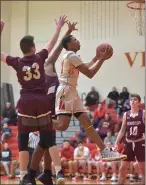  ?? PETE BANNAN — MEDIANEWS GROUP ?? West Chester East’s Tym Richardson scores as West Chester Henderson’s Ryan Kirby defends.