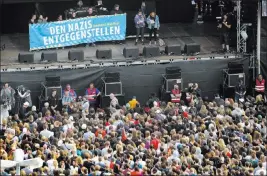  ?? Jens Meyer ?? The Associated Press Visitors listen to speeches Monday before a concert in Chemnitz, Germany, intended to signal opposition to hatred and anti-migrant sentiment. The sign on the stage reads, “Oppose The Nazis, Chemnitz Free Of Nazis.”