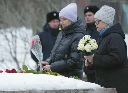  ?? ALEXANDER ZEMLIANICH­ENKO/AP ?? Women pay tribute to Kremlin critic Alexei Navalny on Saturday in Moscow. He died Feb. 16.