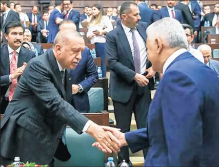  ?? ADEM ALTAN/AFP/GETTY ?? Turkey’s President Recep Tayyip Erdogan, at left, shakes hands with Binali Yildirim, the mayoral candidate for Istanbul who lost for the second time in re-run elections on June 23, against the secular opposition Republican People’s Party (CHP) candidate.