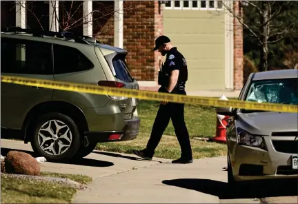  ?? MATTHEW JONAS — STAFF PHOTOGRAPH­ER ?? A police officer walks near an SUV that appears to have shattered windows on Goshawk Drive in Longmont on Wednesday.