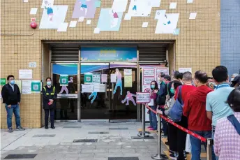  ?? — AFP photos ?? People queue outside a sports centre to receive China’s Sinovac Covid-19 coronaviru­s vaccine in the Kowloon Bay district of Hong Kong.