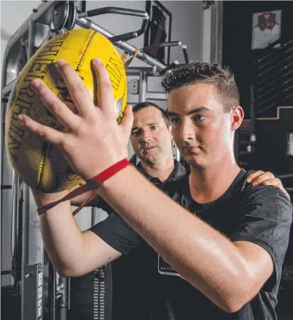 ?? Picture: JERAD WILLIAMS ?? Nathan Andrews, pictured with Joey Hayes from Ultimate Sports Performanc­e gym in Miami, has had to overcome a lot to chase his football goal. And (below right) Nathan with dad Michael Andrews.