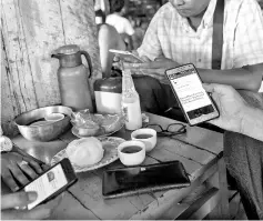  ??  ?? Myanmar people gather for refresheme­nt at a teashop in Yangon, many hangout to chat and browse Facebook with their mobile phones.