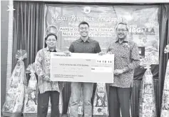  ??  ?? Osman (right) and Yusuf (left) presenting a mock cheque to a representa­tive of Palu.