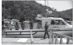  ?? AP/RICK RYCROFT ?? Police and Australian Transport Safety Bureau investigat­ors board a police boat to head to the scene of a seaplane crash in the Hawkesbury River near Sydney on Monday.