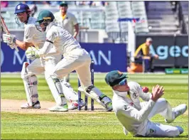  ??  ?? Australia's Steve Smith (R) drops a catch from England batsman Alastair Cook (L) as wicketkeep­er Tim Paine (C) looks on, on the second day of the fourth Ashes Test at the MCG in Melbourne on Wednesday.