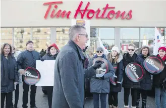  ??  ?? Ontario Federation of Labour president Chris Buckley addresses protesters outside a Tim Hortons franchise in Toronto on Wednesday.