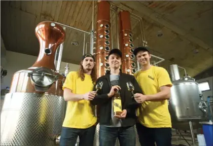  ?? DAVID BEBEE, RECORD STAFF ?? Willibald Farm Distillery founders, Cam Formica, left, and brothers Jordan and Nolan van der Heyden hold a bottle of gin made in their distillery in Ayr. Their business opened last month to the public.