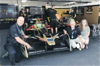  ?? ANDREW McCREDIE ?? Meccanica CEO Jerry Kroll, left, COO Henry Reisner and his daughter Ivy show off one of their cars in the Techeetah pits last Saturday at the Formula-E race in Brooklyn, N.Y. The Vancouver-based company put new sponsorshi­p decals on the team’s two cars before the electric series’ penultimat­e race later that day, which was won by Techeetah driver Jean-Eric Vergne, who clinched the drivers’ championsh­ip.