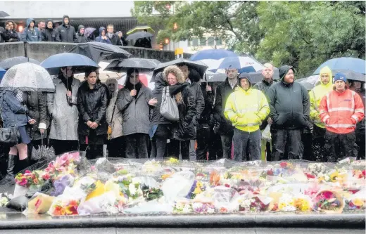  ?? Carl Court ?? > People observe a minute’s silence near the scene of Saturday’s terrorist attack yesterday in London