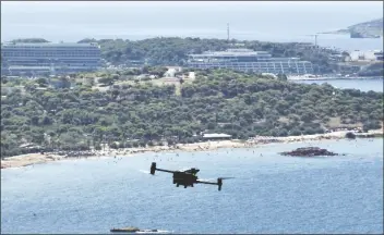  ?? THANASSIS STAVRAKIS/AP ?? A LONG-RANGE DRONE equipped with thermal imaging cameras and a sophistica­ted early warning system patrols over Kavouri beach and nearby woodland, in southern Athens, Greece, on Aug. 17.
