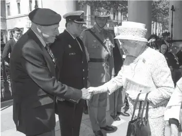  ?? ASSOCIATED PRESS ?? Britain's Queen Elizabeth II meets WWII veteran Robert Hucklesbur­y at St Martin-in-theFields Church in London, as they attend a service of commemorat­ion marking the 70th anniversar­y of VJ Day.