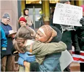  ?? — AP ?? Demonstrat­ors embrace as they gather in solidarity against President Donald Trump’s executive order outside City Hall in Cincinnati.