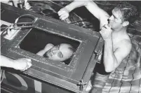  ?? RON BURTON GETTY IMAGES FILE PHOTO ?? The Amazing Randi peers out from a sealed coffin in which he attempted to break his own endurance record of staying under water for two hours in 1958. Randi, left, died Tuesday at age 92.