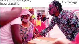  ?? CONTRIBUTE­D PHOTOS ?? Bounty Killer donates grocery items to a resident of the Majesty Gardens community.