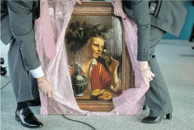  ?? MARY ALTAFFER / THE ASSOCIATED PRESS ?? FBI agents unwrap Young Man As Bacchus by Jas Frans Verzijl before a ceremony to return the painting to the Max and Iris Stern Foundation.