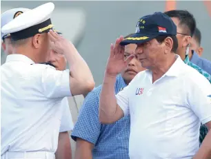  ?? Reuters ?? Philippine President Rodrigo Duterte returns the salute of a Chinese Navy officer as he tours a Chinese Naval ship during a visit to Davao city, southern Philippine­s, on Monday. —