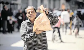  ?? MOHAMMED ALI Xinhua/Sipa/USA TODAY NETWORK ?? A man returns home after receiving bread at one of three bakeries in Gaza City which recently opened in coordinati­on with the United Nations World Food Program, after ceasing operations since the start of the Israel-Hamas war.