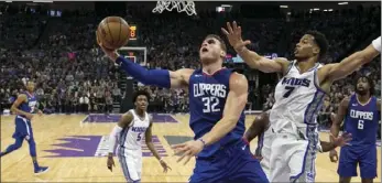  ??  ?? Los Angeles Clippers forward Blake Griffin (front left), goes to the basket against Sacramento Kings forward Skal Labissiere during the first quarter an NBA basketball game Saturday in Sacramento. AP PHOTO/RICH PEDRONCELL­I