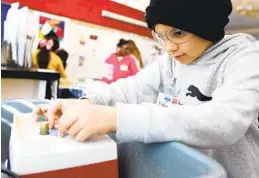  ?? K.C. ALFRED U-T ?? Normal Heights Elementary fourth-grader Valentin Camargo shapes a tile for the mosaic mural he and other students are making.