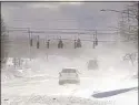  ?? Mark Mulville / Associated Press ?? Cars drive through blowing, drifting snow in Erie County, N.Y.