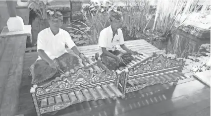  ??  ?? Balinese musicians play the rindik, a traditiona­l instrument made from bamboo, at the Four Seasons Resort at Jimbaran Bay.